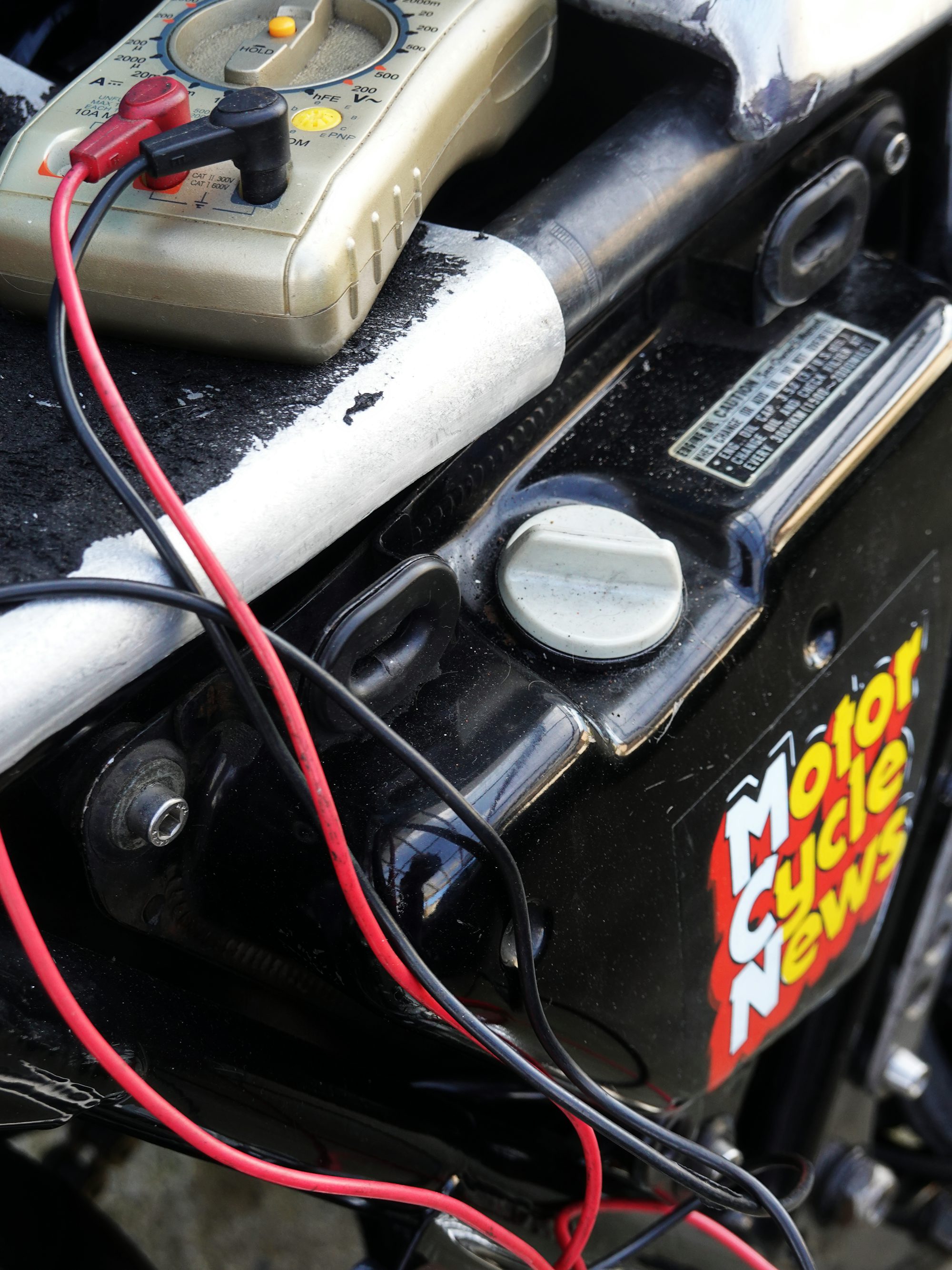 A multimeter's probes testing battery voltage during a diagnostic check