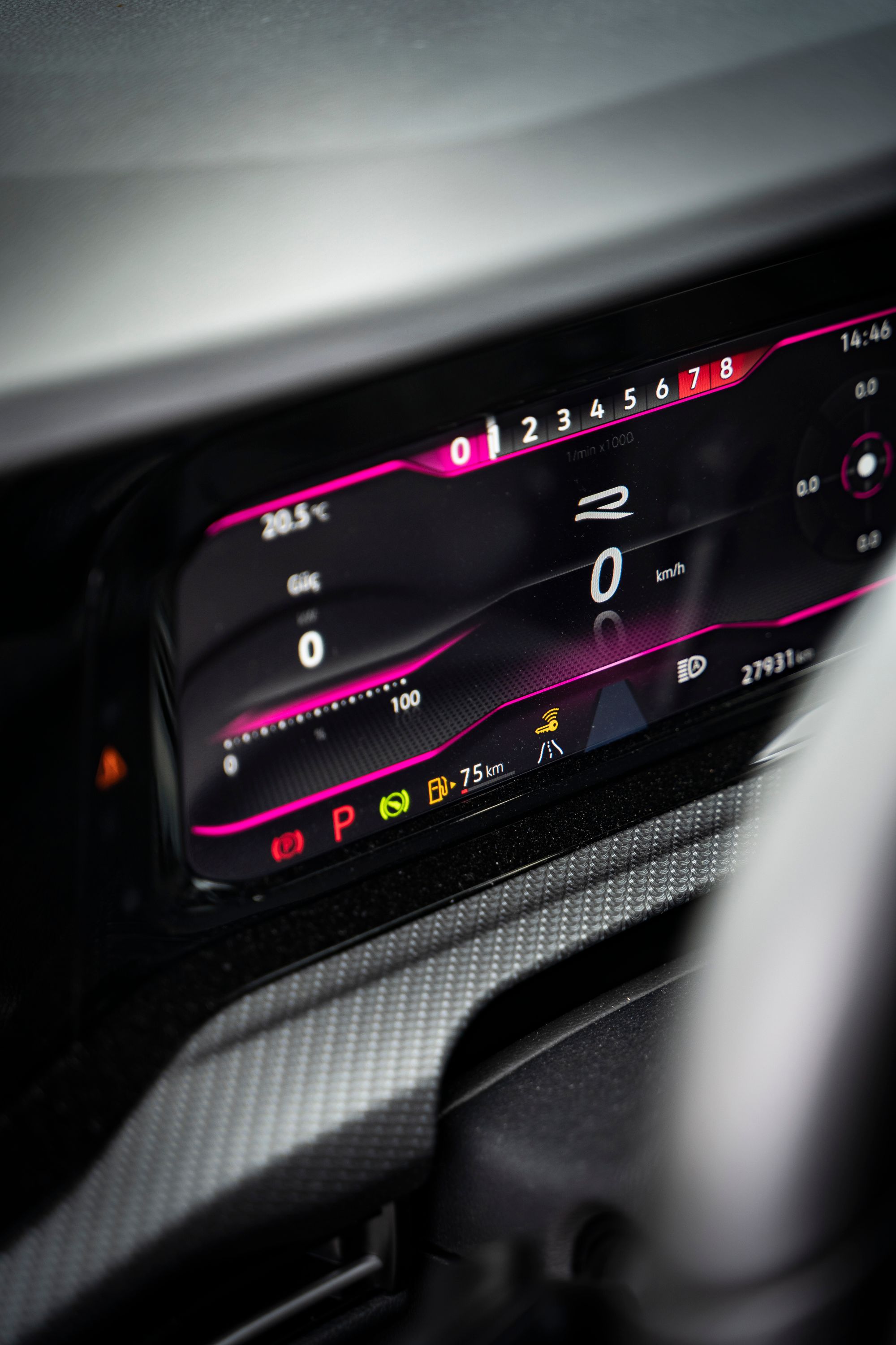 A digital car dashboard at night showing speed, temperature readings, and warning indicator lights